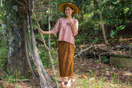 young asian female farmer showing thumb in rice fieldの写真素材