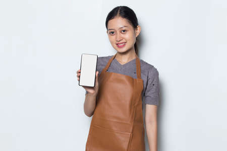 Asian Barista waitress using mobile smartphoneの写真素材
