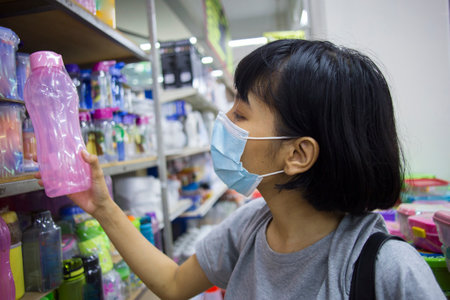 Young asian woman with face mask  buying groceries in the supermarket during virus pandemicの写真素材
