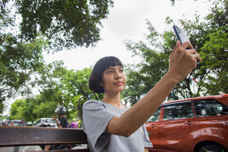 Young asian woman selfie with mobile phone  in public spaces.