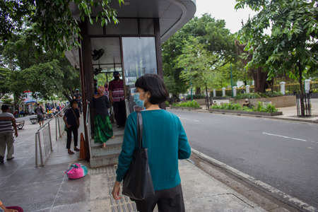 Asian Woman with medical mask waiting for the bus on public transportation station