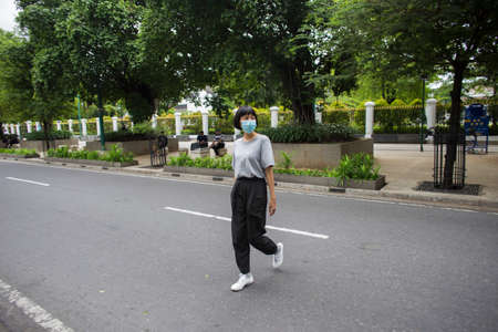 Asian Woman with medical mask crossing the road