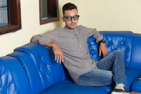 Happy young handsome man relaxing at home