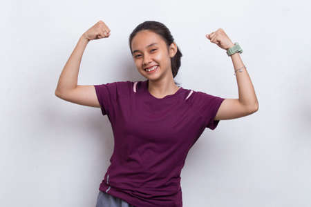 young sporty asian beautiful showing strong gesture on white backgroundの写真素材