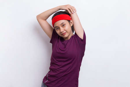 young asian sporty woman doing stretching on white backgroundの写真素材