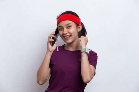 young asian sporty woman using mobile phone on white background