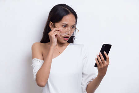 shock young asian beautiful woman using mobile phone isolated on white background