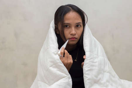 young beautiful asian girl sick and cough in the bedroom women health careの写真素材