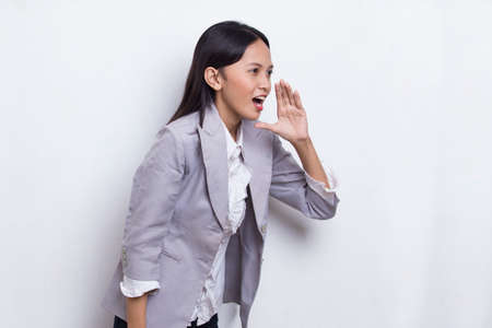 young asian business woman shouting and yelling announcing isolated on white backgroundの写真素材