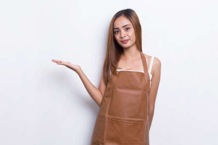 Happy young asian woman barista waitress pointing with fingers to different directions isolated on white backgroundの写真素材