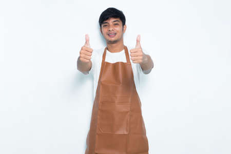 Asian apron man smiling happy with ok sign gesture tumb up isolated on white backgroundの写真素材