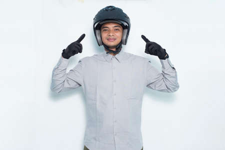 handsome asian man with a motorcycle helmet showing a thumbs up ok gesture on white background