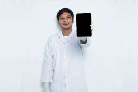 portrait of asian medical doctor demonstrating mobile cell phone isolated on white background