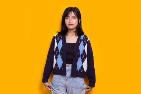 portrait of cute beautiful young asian woman isolated on yellow background