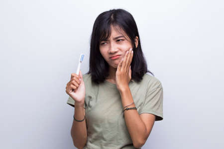 beautiful young woman suffering from toothache pain  tooth decay  tooth   dental care concept on white backgroundの写真素材