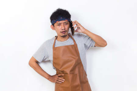 shock asian man barista bartender or waitress using mobile smartphone isolated on white backgroundの写真素材