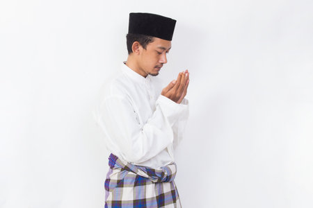shock and confused asian muslim man using mobile phone isolated on white backgroundの写真素材