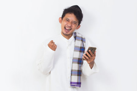 shock and confused asian muslim man using mobile phone isolated on white background