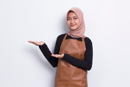 asian muslim woman barista waitress pointing with fingers to different directions isolated on white backgroundの写真素材