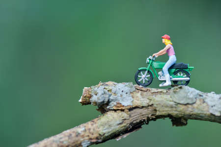 Miniature people figure motorcyclists are touring in the forestの写真素材