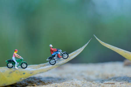 Miniature people figure motorcyclists are touring in the forest