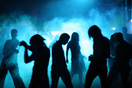 Silhouettes of a dancing teenagers in a discoの写真素材