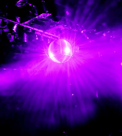 purple shining disco ball in a discoの写真素材