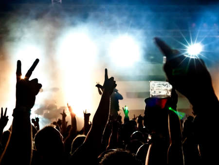 silhouettes of concert crowd in front of bright stage lights