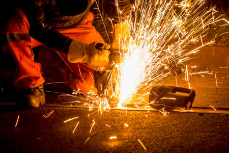 Worker cutting train tracks