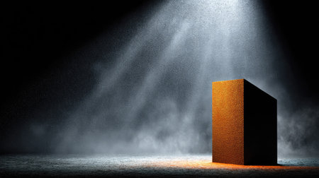 Rust-colored block-shaped podium sits on a dark, concrete surface under a spotlight that creates a dramatic scene, enhanced by smoke effects and a dark backdrop.の素材