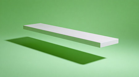 Single, elongated, rectangular object, rendered in bright white, appears suspended in mid-air against a uniform, bright, spring green background. A strong, dark shadow stretches diagonally across the lower portion of the background plane, emphasizing the object's height and the dramatic lighting setup.の素材