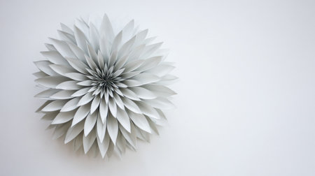 Meticulously constructed, monochromatic decoration resembling a multi-petaled flower, possibly made from folded or cut paper, is positioned on the left side of the frame, leaving significant empty white space on the right for text or design elements.の素材
