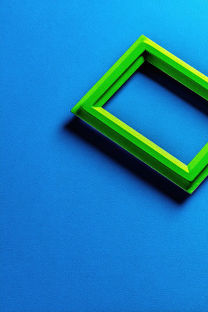A bright green rectangular frame sits on a textured blue surface.の素材