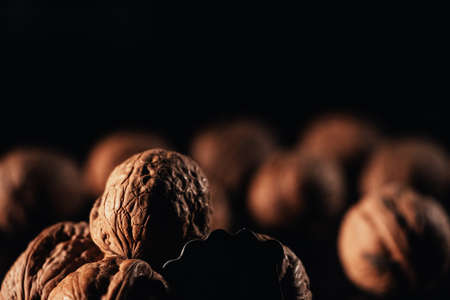 walnuts on a black background, you can see a cracked walnut, selective focus.
