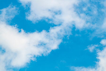 Vibrant blue sky with billowing white clouds, providing a stunning backdrop to any compositionの写真素材