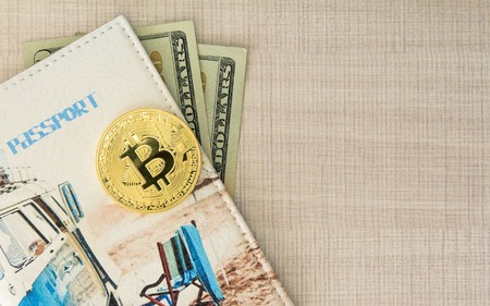 Bitcoin golden coin with passport cover and dollars money. Copy spase for text on the wooden backgroundの写真素材