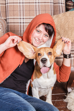 Young smiling girl with happy and silly beagle dog who shows the tongueの写真素材