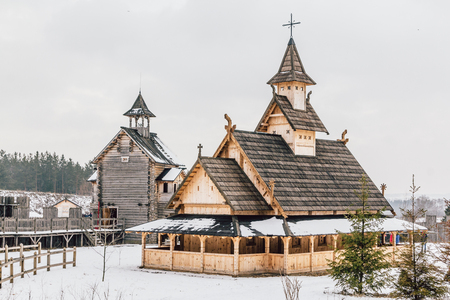 Ancient wooden Slavic church on a snowy landscape. Historical and Architectural Museum in the open air. Kiev, Ukraine, Ancient park Kievskaya Rus'.の写真素材