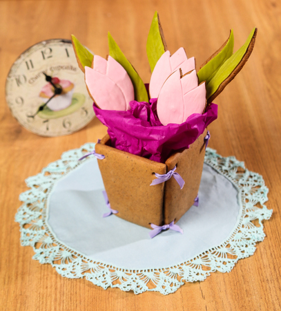 Homemade Ginger Cookies in the shape of a basket of tulip flowers on the blue napkin on wooden background. Closeup view, square pictureの写真素材