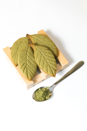 Homemade matcha green tea shortbread cookies in shape of of green tea leaves isolated on white background.の写真素材