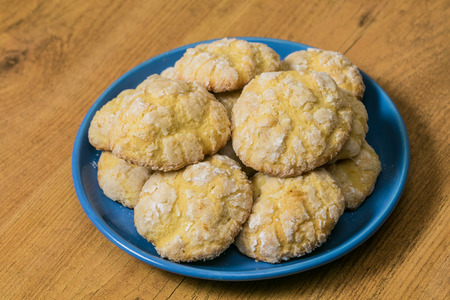 Homemade Lemon Sugar cookies stacked on the blue saucer at wooden backgroundの写真素材
