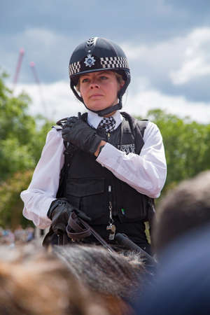 Police woman riding a horse in front of Buckingham Palace in Londonのeditorial素材