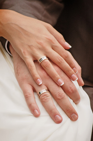 groom with the bride holding hands together with wedding ringsの写真素材