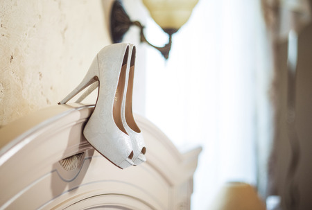white bride shoes hanging on the back of the bed in the roomの写真素材