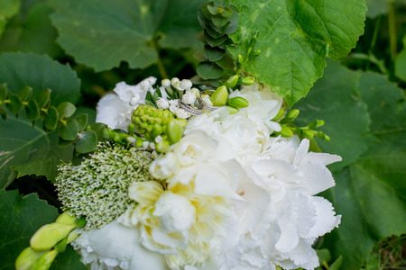 bouquet of the bride with wedding rings lies on the grass in the parkの写真素材