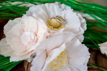 wedding gold rings lie on a bouquet of the brideの写真素材