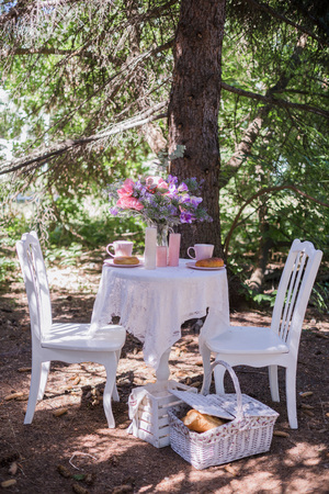 white chairs with table stand in the gardenの写真素材