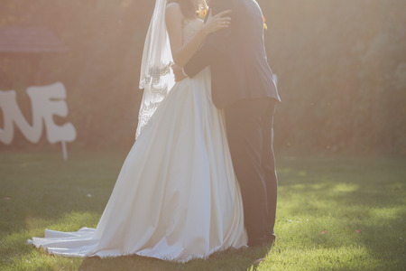 bride and groom together in the autumn on the grassの写真素材