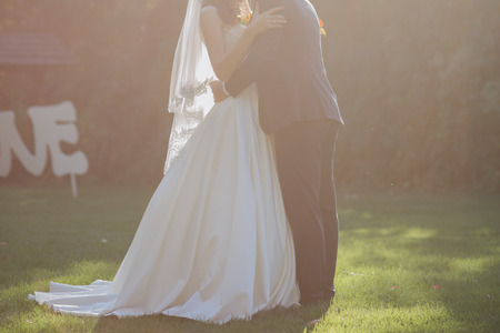 bride and groom together in the autumn on the grassの写真素材
