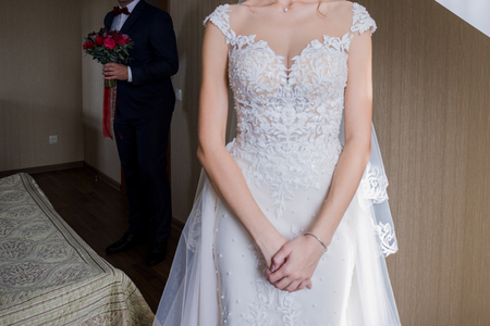 the bride is standing in the room in a dressの写真素材
